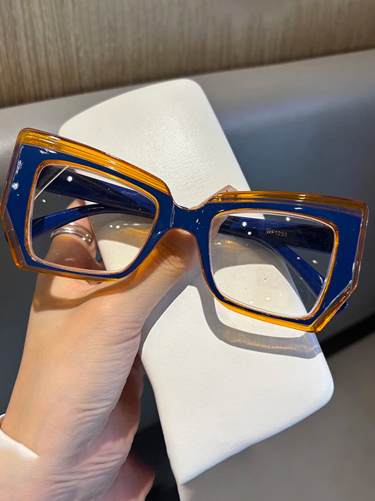 Hand holding blue orange cat eye glasses with white case