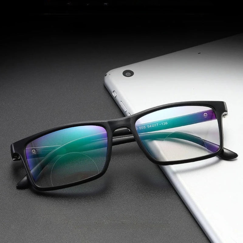 Black progressive glasses resting on a tablet surface