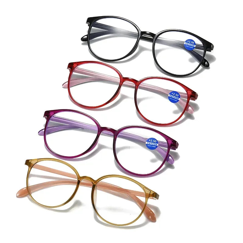 Four pairs of reading glasses in black, red, purple, and yellow