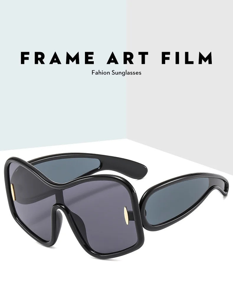 Black frame oversized shield sunglasses with dark lenses and 'FRAME ART FILM' label
